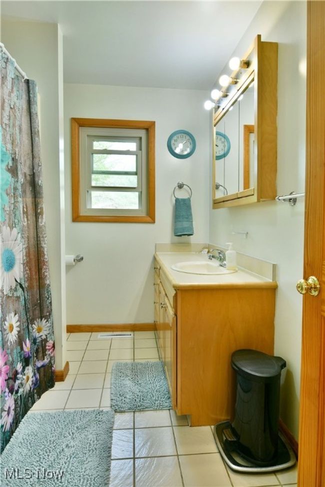 Full bath with vanity, tile patterned flooring, baseboards, and a shower with shower curtain | Image 19