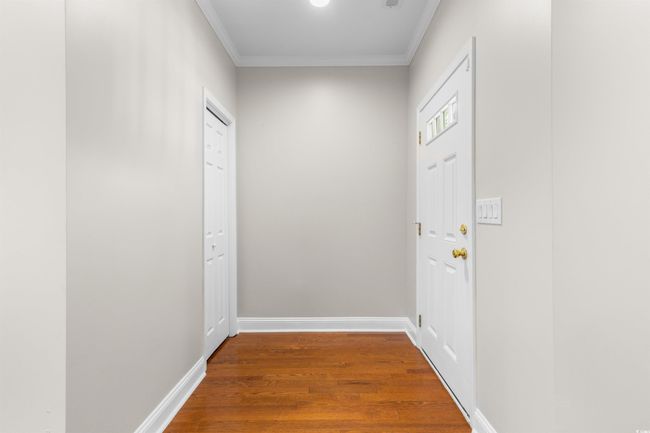 Corridor featuring ornamental molding, wood finished floors, and baseboards | Image 7