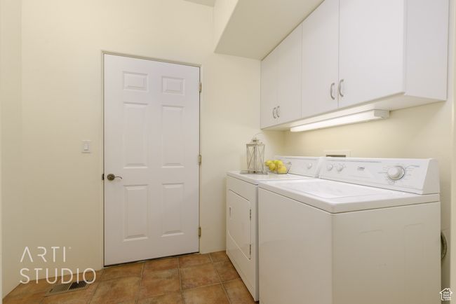Washroom with cabinet space, separate washer and dryer, and visible vents | Image 40