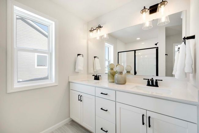 Primary bath includes double sink vanity and large shower with ceramic tile walls. | Image 13