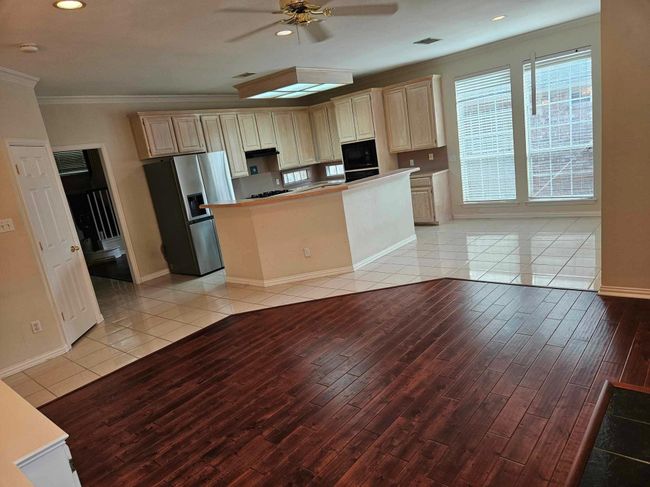 Kitchen with stainless steel fridge, light wood-style floors, ornamental molding, a ceiling fan, and recessed lighting | Image 18
