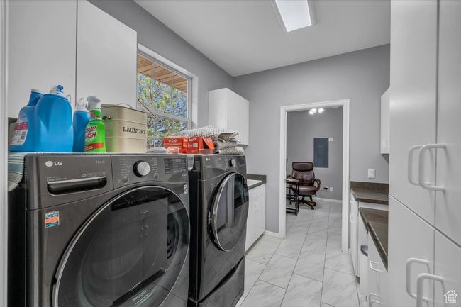 Washroom with electric panel, marble finish floor, independent washer and dryer, and cabinet space | Image 31