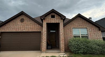 View of property with a garage and a front lawn | Image 1