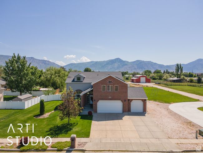 View of front facade featuring brick siding, concrete driveway, a garage, and a mountain view | Image 40