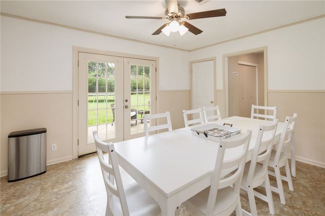 Dining space featuring french doors, a ceiling fan, and wainscoting | Image 11