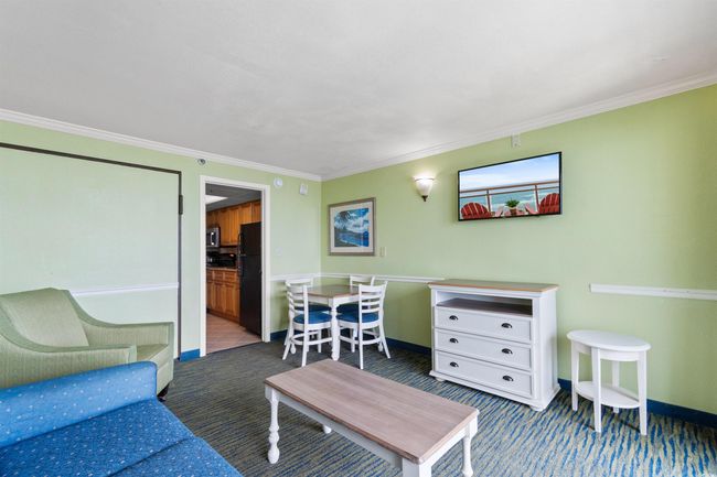 Carpeted living room featuring crown molding and baseboards | Image 6