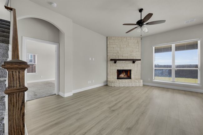 Living room featuring light wood-type flooring, a fireplace, and a wealth of natural light | Image 5
