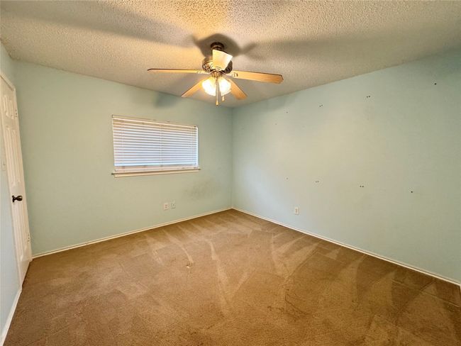 Carpeted spare room with a ceiling fan and a textured ceiling | Image 10