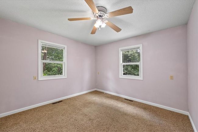 Carpeted spare room with baseboards, visible vents, and plenty of natural light | Image 57