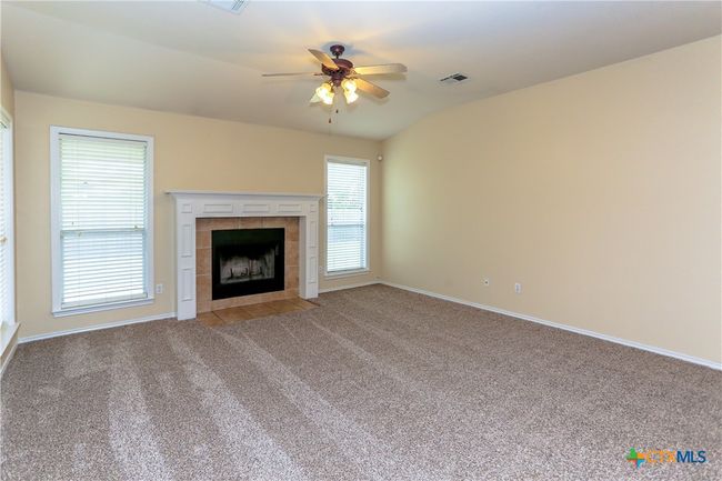 Living room with new carpet, windows for lots of natural light, and fireplace. | Image 17