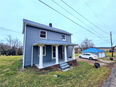 View of front facade with a garage, covered porch, and a front lawn | Image 2