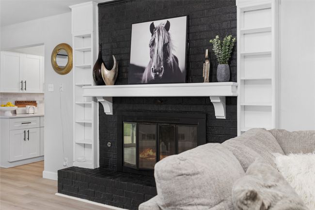 Interior details with a fireplace, wood finished floors, baseboards, built in features, and tasteful backsplash | Image 7