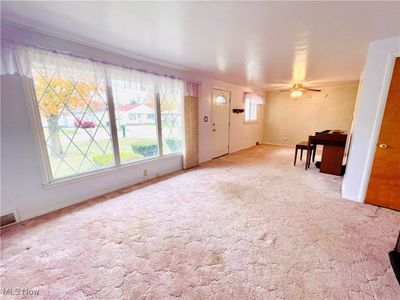 Unfurnished living room featuring ceiling fan and light carpet | Image 3