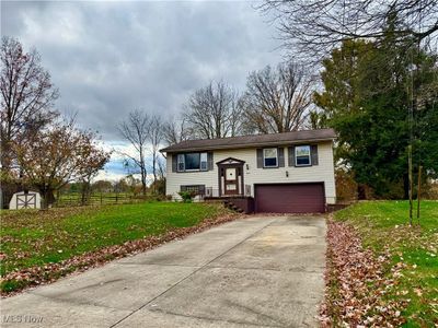 Raised ranch featuring a garage and a front yard | Image 1