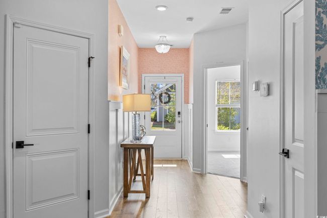 Hallway with baseboards, visible vents, light wood-style floors, and wallpapered walls | Image 4