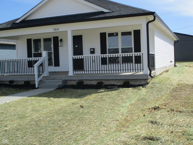 view of front of home with a front lawn, covered porch, and a shingled roof | Image 21