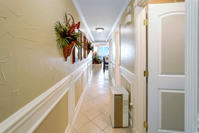 Corridor with ornamental molding, light tile patterned floors, and a decorative wall | Image 20