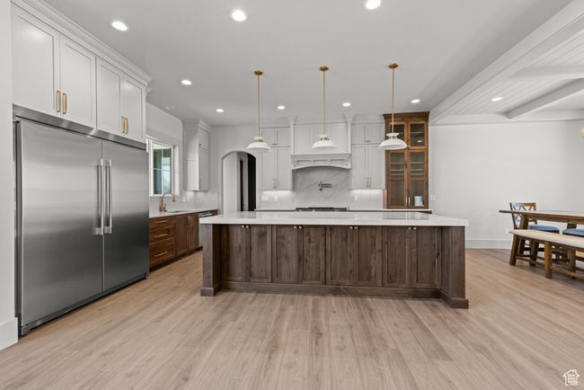 Kitchen with stainless steel appliances, light countertops, recessed lighting, tasteful backsplash, and light wood-style flooring | Image 7