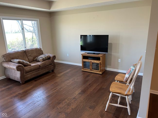 living room featuring baseboards and dark wood-style flooring | Image 7