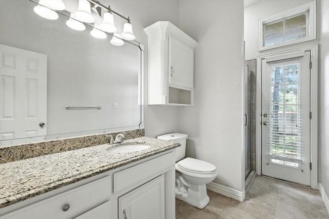 Full bath down featuring vanity, plenty of natural light, a shower stall, and patio access | Image 18