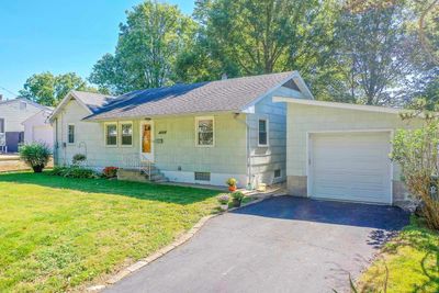 Ranch-style home with a front yard and a garage | Image 1