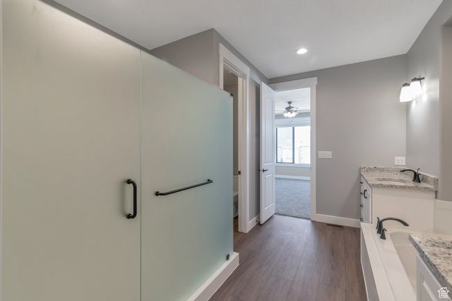 Full bathroom featuring vanity, wood finished floors, recessed lighting, a stall shower, and ceiling fan | Image 20
