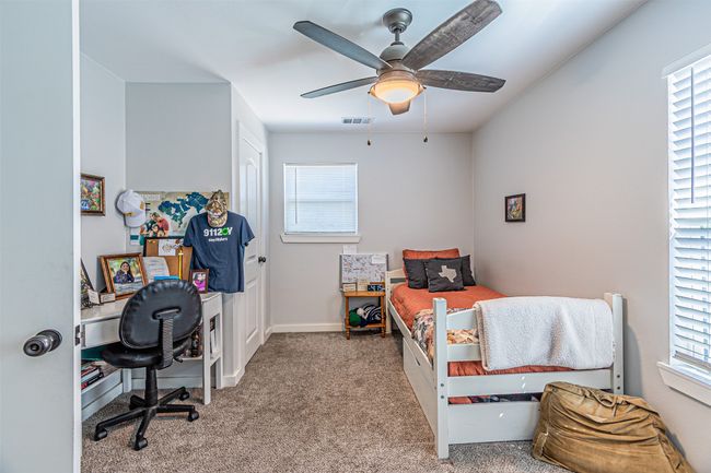 Bedroom with carpet floors, an office area, and a ceiling fan | Image 27