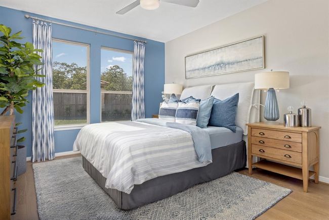 What a wonderful place to come home to, this stunning primary suite greets you with gorgeous engineered wood flooring, custom paint, high ceiling, ceiling fan with lighting, lovely large windows allowing in natural light brightening up this spacious primary bedroom! | Image 5