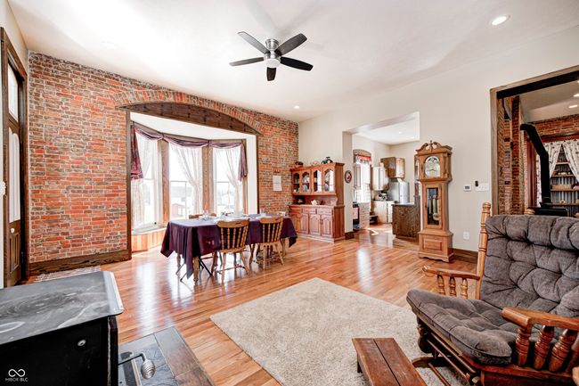 living room with baseboards, brick wall, ceiling fan, recessed lighting, and light wood-style flooring | Image 17