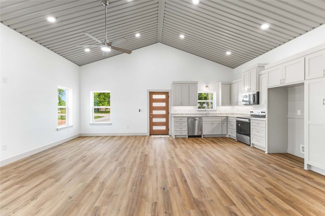 Kitchen with appliances with stainless steel finishes, high vaulted ceiling, a sink, ceiling fan, and open floor plan | Image 9