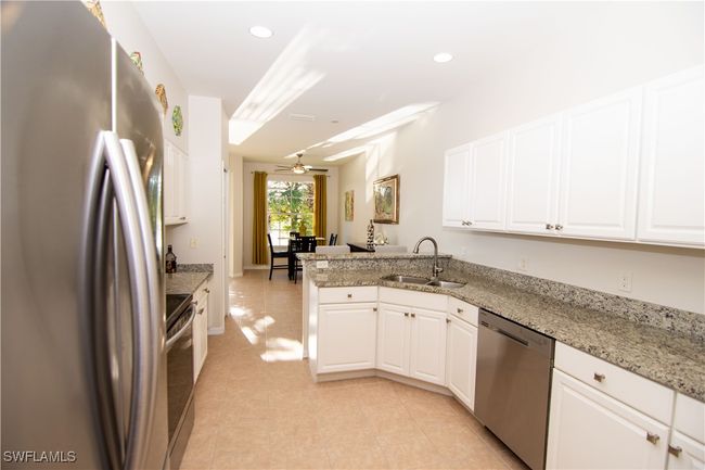 Large kitchen with many white cabinets and beautiful granite. | Image 9