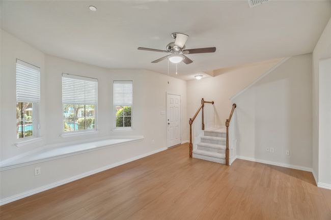 You enter thru the front door into the main living area with a beautiful bay window, ceiling fan and natural light. | Image 4