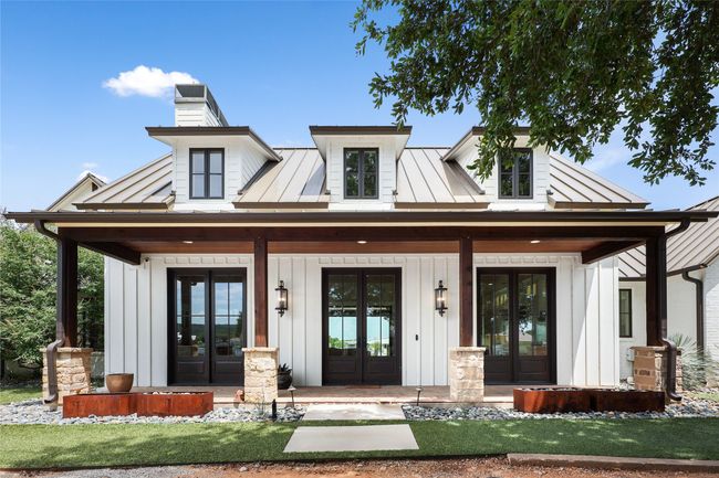 View of front of property featuring french doors, board and batten siding, and covered porch | Image 6