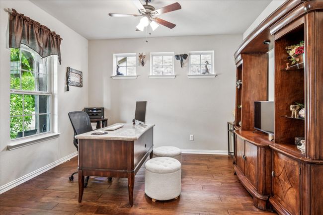 Office area featuring plenty of natural light, a ceiling fan, dark wood-type flooring, and baseboards | Image 6