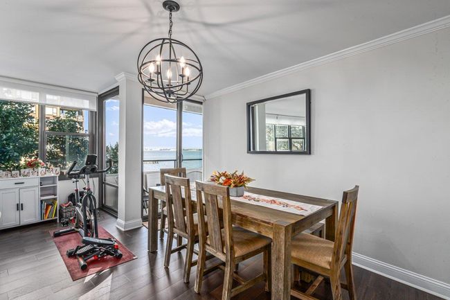 Dining room featuring a chandelier, a water view, ornamental molding, and dark wood-type flooring | Image 13