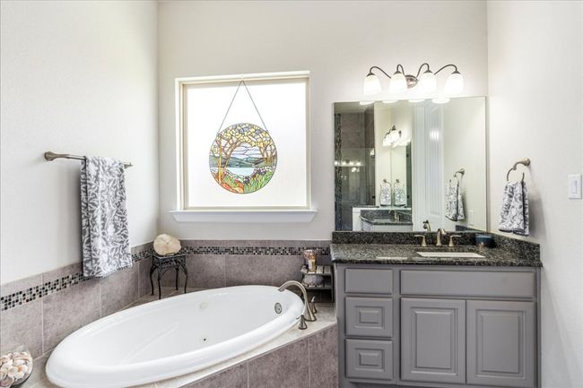 Full bathroom featuring vanity, a whirlpool tub, and a shower stall | Image 19