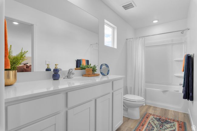 Bathroom featuring vanity, wood finished floors, shower / bath combo, and recessed lighting | Image 16