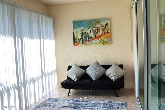 Living area featuring a textured wall and tile patterned floors | Image 12