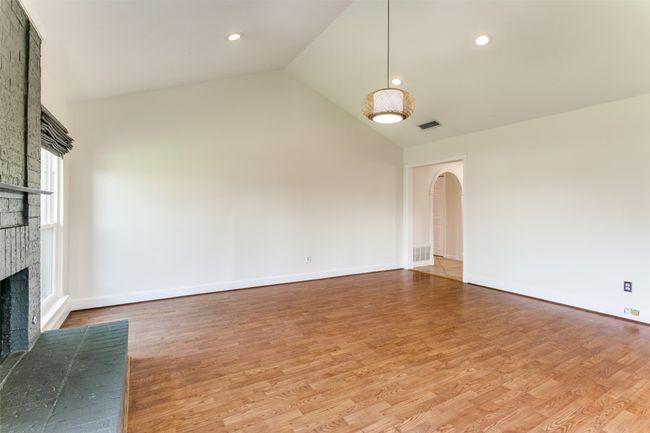Large family room with vaulted ceilings and wood flooring. | Image 18