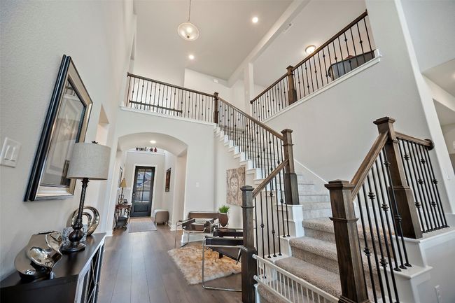 Entrance foyer featuring a high ceiling, arched walkways, stairway, dark wood-style floors, and recessed lighting | Image 14