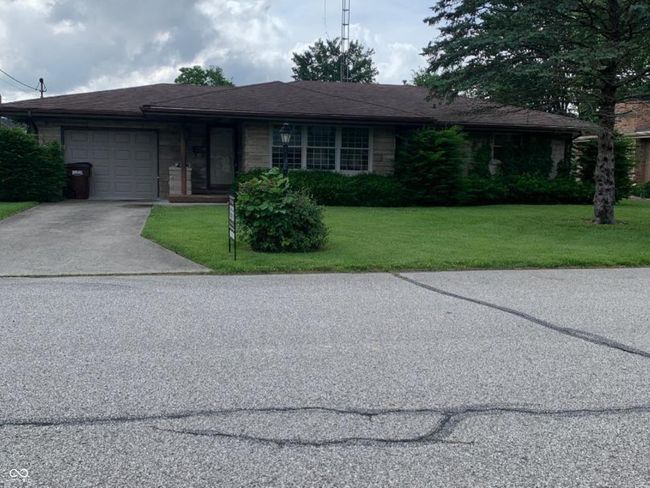 ranch-style house with an attached garage, concrete driveway, and a front yard | Image 12