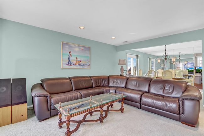 Living room with carpet flooring, a wealth of natural light, and an inviting chandelier | Image 8