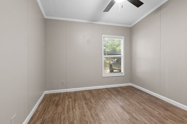 Empty room featuring ornamental molding, wood finished floors, and ceiling fan | Image 29