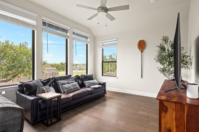 Living area with a ceiling fan, wood finished floors, and lofted ceiling | Image 21