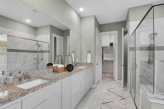 Bathroom with a marble finish shower, double vanity, marble finish flooring, a spacious closet, and baseboards | Image 14