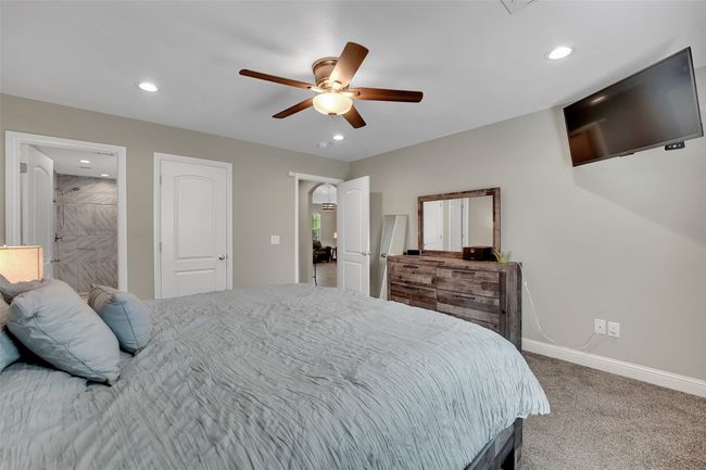 Carpeted bedroom featuring ensuite bathroom, baseboards, recessed lighting, and a ceiling fan | Image 23