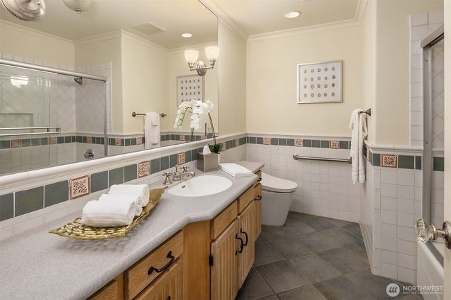 A full guest bathroom on the main floor features toasty heated floors for those days when you really need it! | Image 23