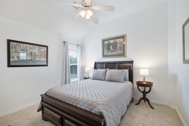 Bedroom with light colored carpet, lofted ceiling, and ceiling fan | Image 26