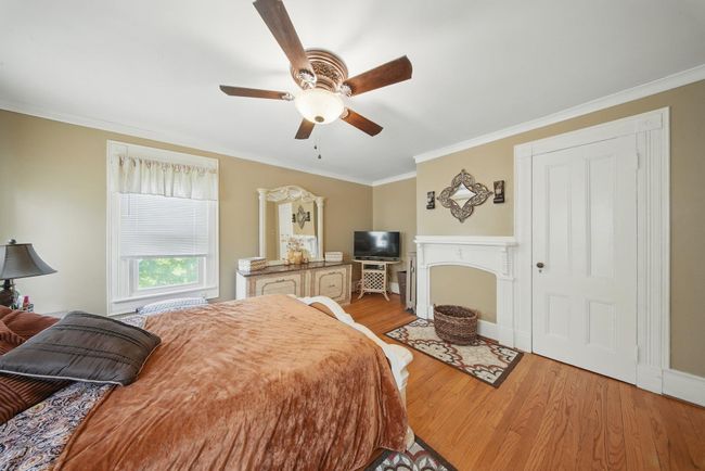 Bedroom featuring light wood-style flooring, ornamental molding, and a ceiling fan | Image 22