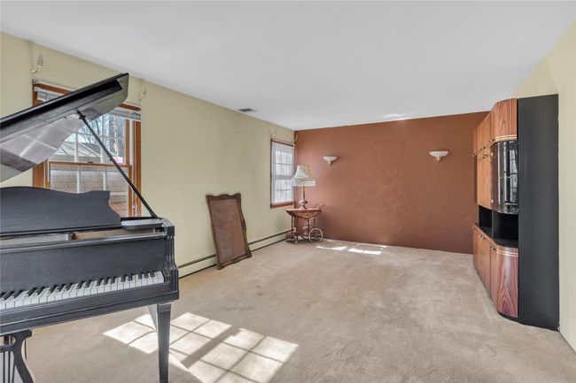 Sitting room featuring light colored carpet, visible vents, and a baseboard radiator | Image 4